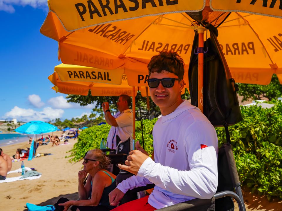 Crew under the yellow PARASAIL umbrellas on Kāʻanapali Beach
