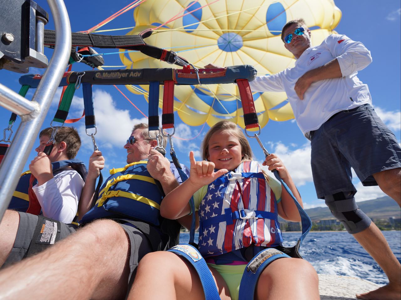 A young flyer throwing a shaka in the harness before takeoff