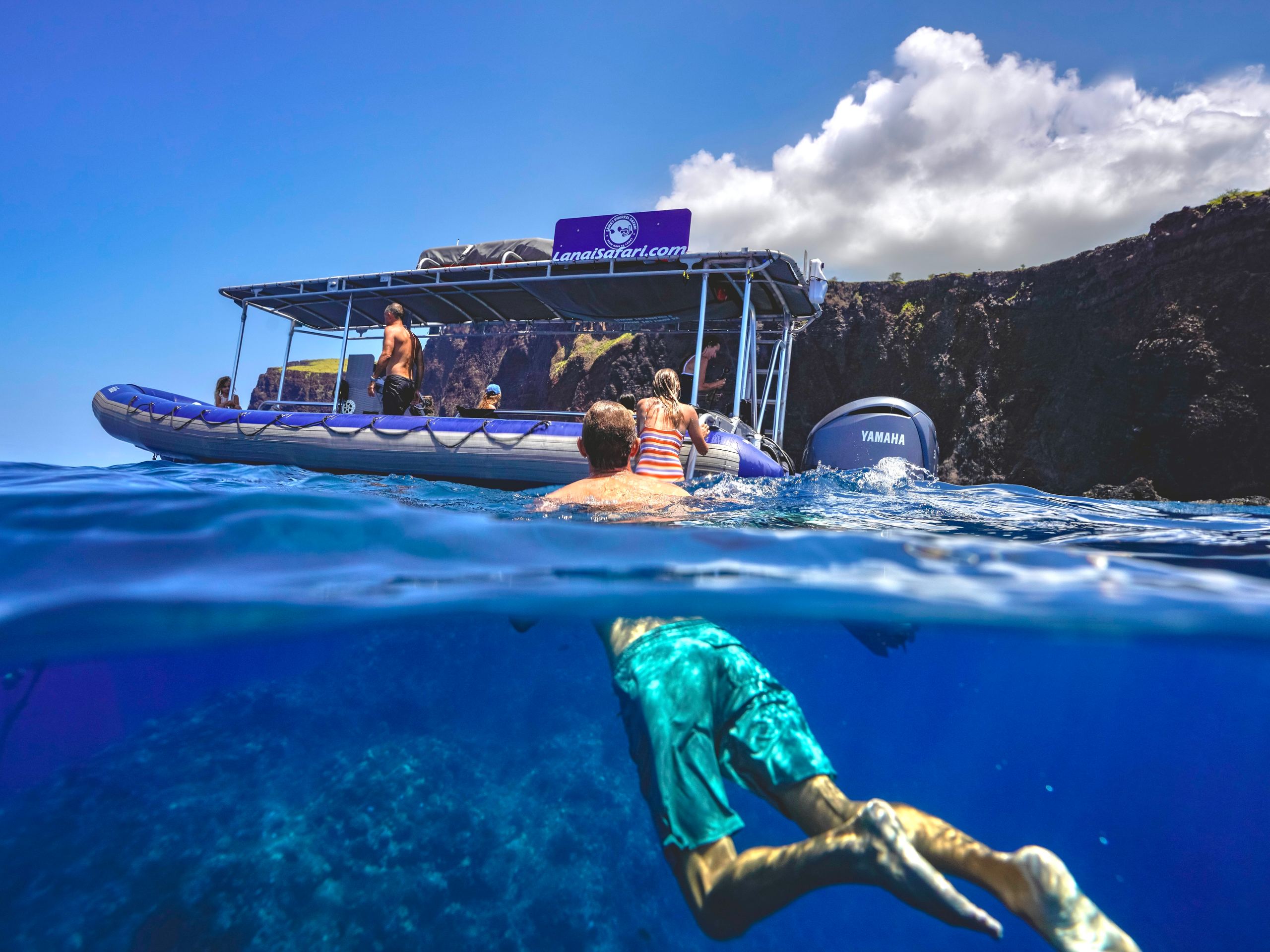 A snorkeler under the surface beside the Lānaʻi Snorkel Safari raft
